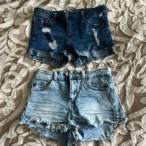 Two pairs of jeans shorts, one deeper blue, one light blue.